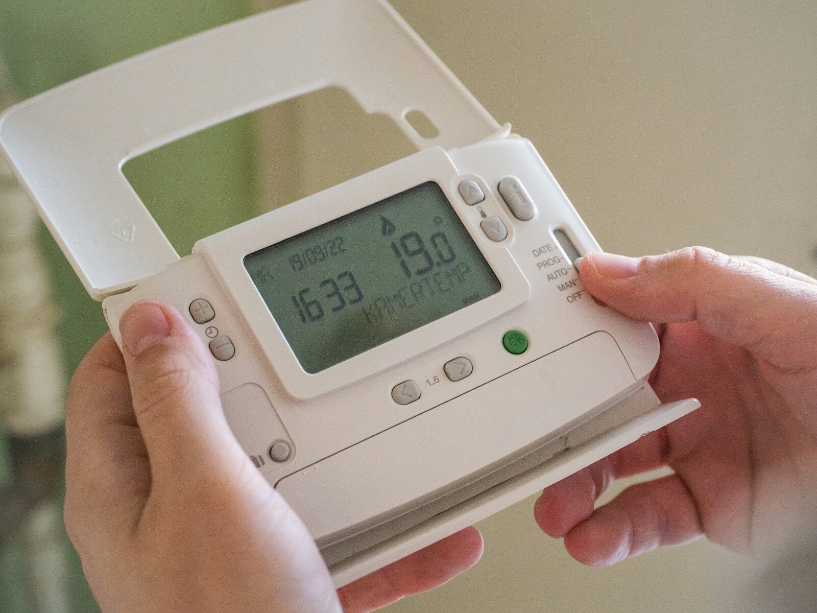 Personne tenant un thermostat