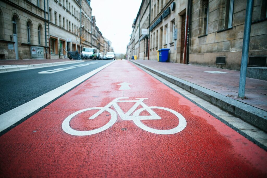 Signe vélo peint en blanc sur une piste cyclable rouge
