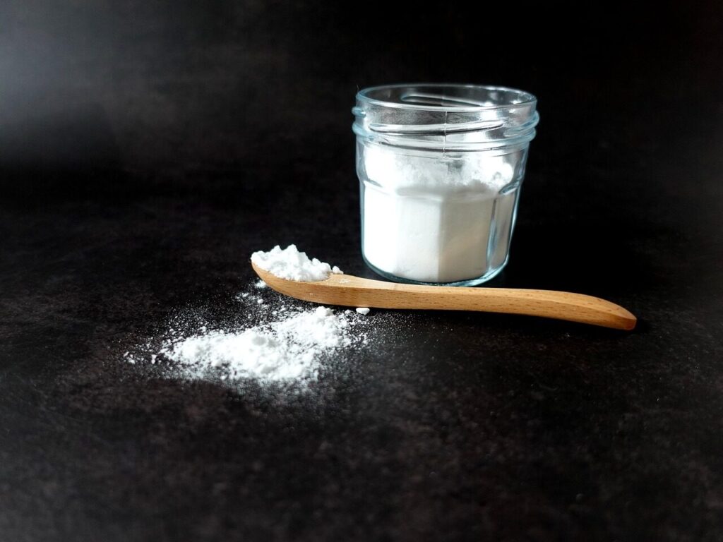Bicarbonate de soude dans un bocal avec une cuillère en bois