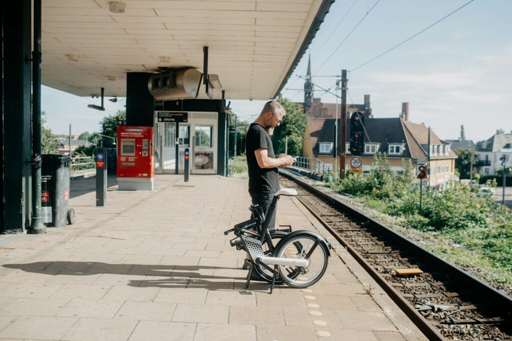 Une personne attendant son train avec un vélo pliable