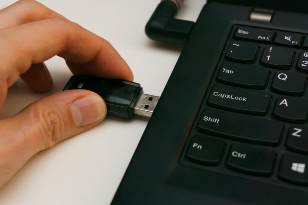 Personne branchant une clé USB à un ordinateur portable
