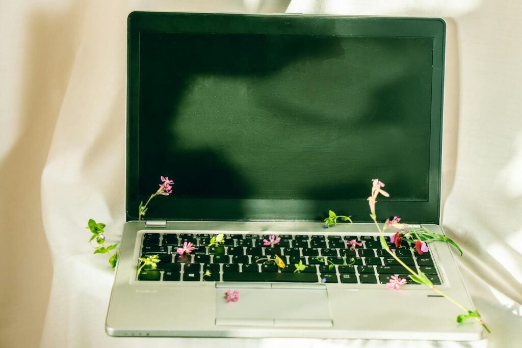Ancien ordinateur portable avec des fleurs, symbolisant la seconde vie